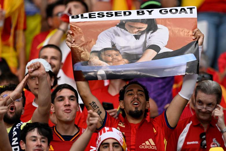 Spain fans hold a banner showing Lionel Messi bathing baby Lamine Yamal before the Euro 2024 final against England.
