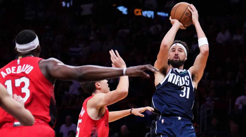 Dallas Mavericks guard Klay Thompson rises for a jump shot over the Miami Heat defense, including Bam Adebayo, during an NBA game.