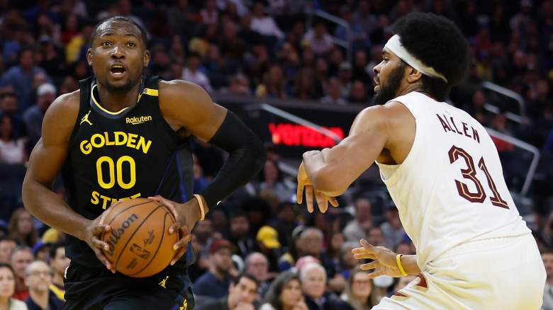 Golden State Warriors forward Jonathan Kuminga drives toward the basket against Cleveland Cavaliers center Jarrett Allen during an NBA game.