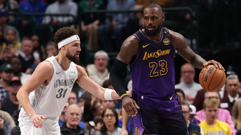 Los Angeles Lakers forward LeBron James dribbles the ball while Dallas Mavericks guard Klay Thompson defends during an NBA game.