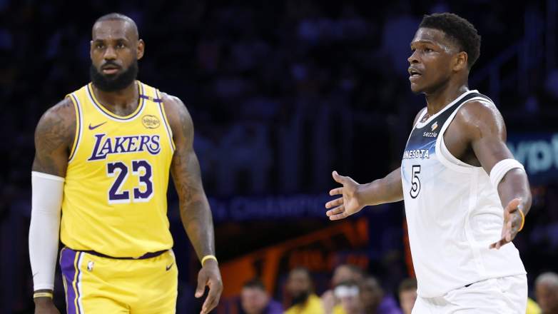 Anthony Edwards gestures with his arms extended while LeBron James stands nearby during a Timberwolves-Lakers game.