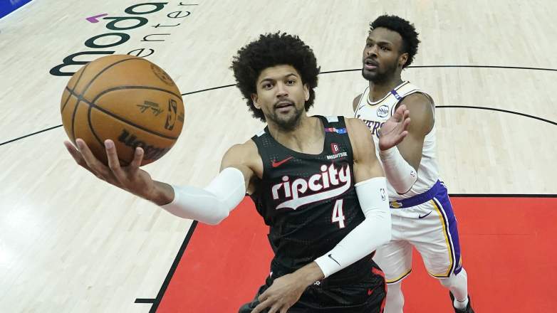 Portland Trail Blazers guard Matisse Thybulle attempts a layup while Los Angeles Lakers guard Bronny James defends during an NBA game.