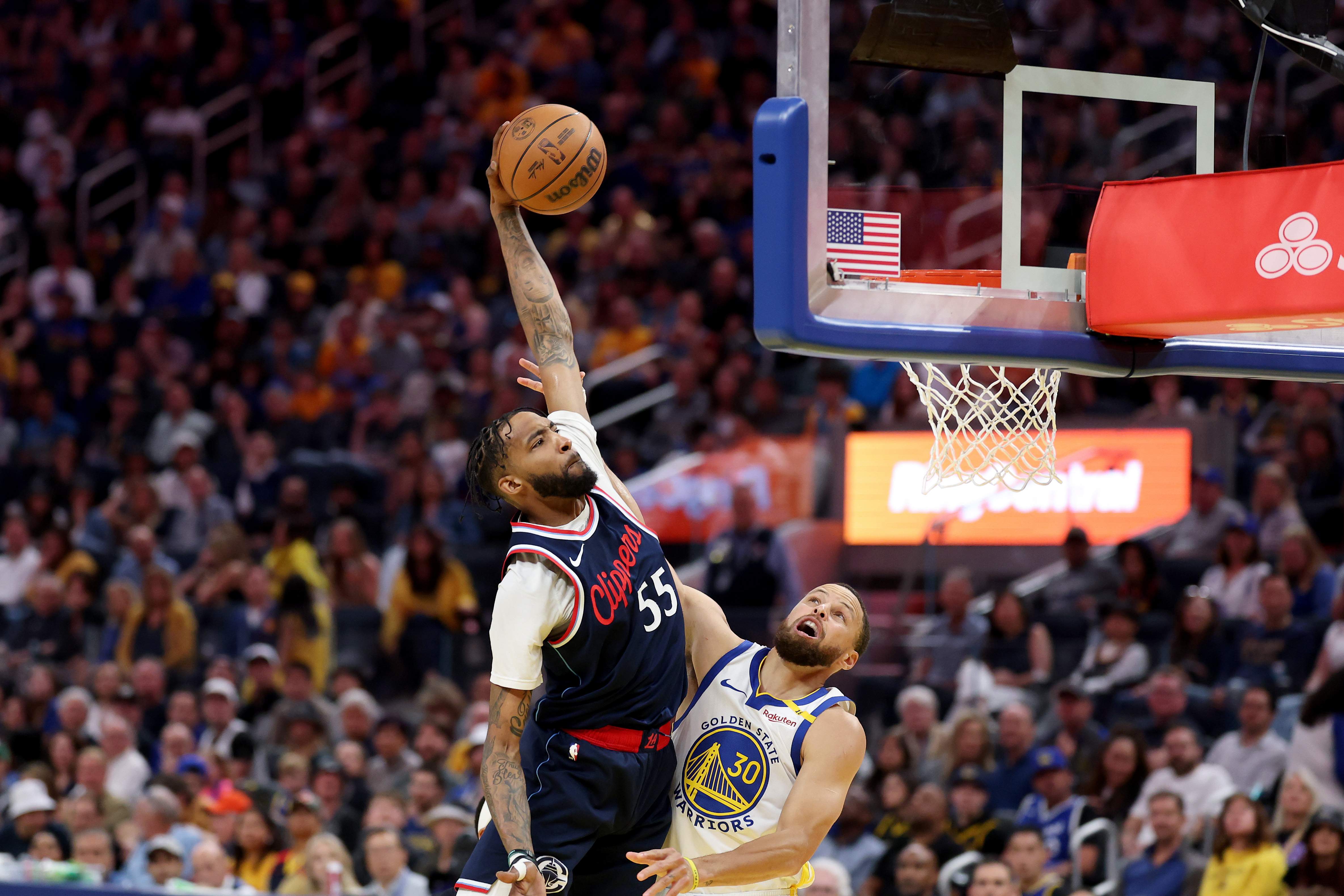 Derrick Jones Jr. attempts a dunk over Stephen Curry during a Clippers-Warriors game as the Nuggets are linked to the veteran wing in Peyton Watson trade rumors.