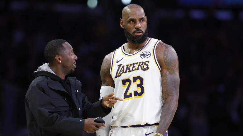 Rich Paul speaks with LeBron James on the court before a Los Angeles Lakers game.