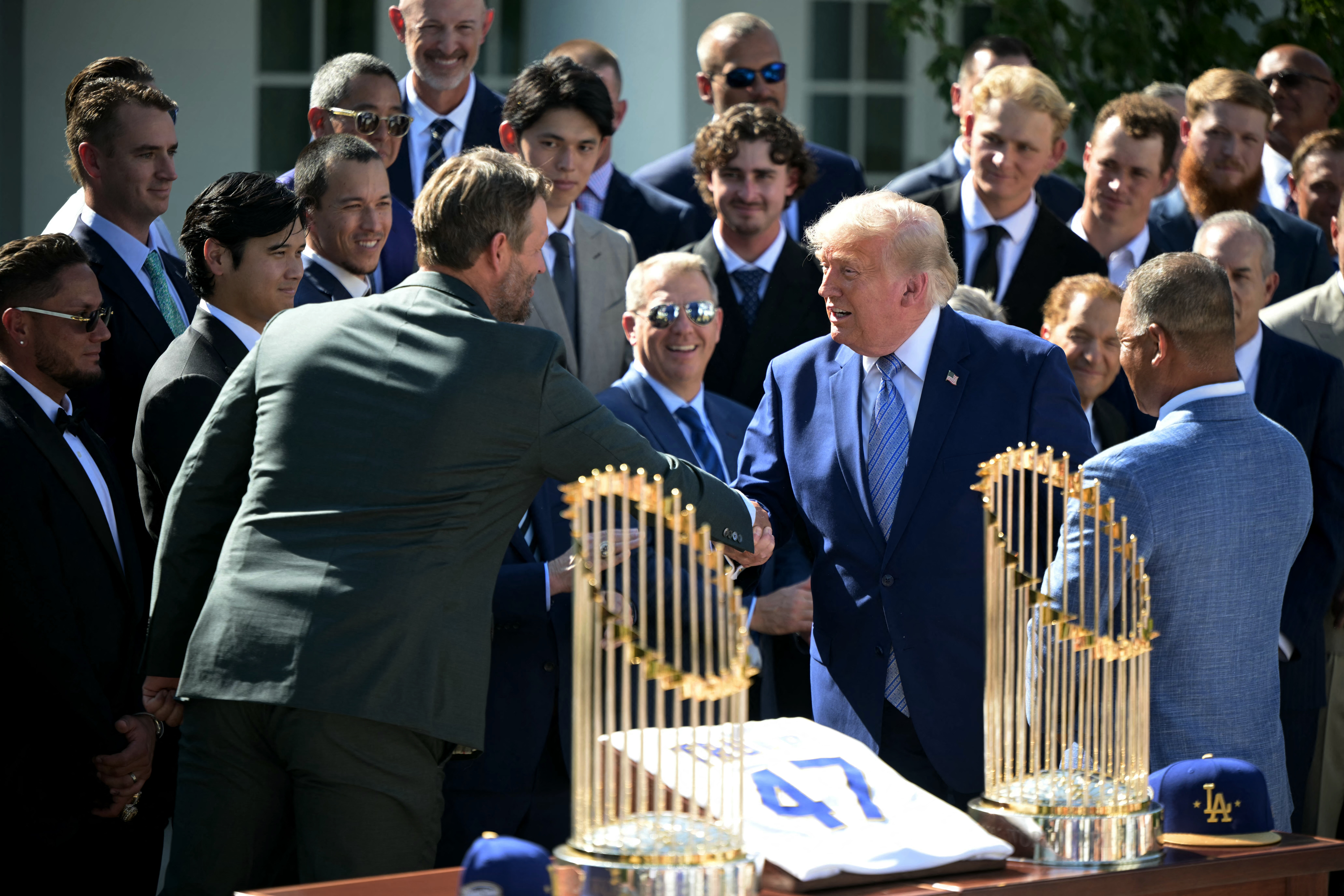 Los Angeles Dodgers pitcher Clayton Kershaw shakes hands with Donald Trump at White House after Trump asks him he is still pitching in the MLB.
