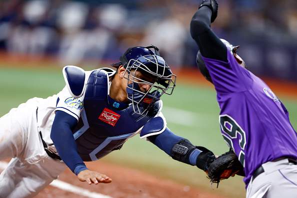 ST PETERSBURG, FLORIDA - AUGUST 23: Christian Bethancourt #14 of the Tampa Bay Rays tags out Jurickson Profar #29 of the Colorado Rockies at the plate during the sixth inning at Tropicana Field on August 23, 2023 in St Petersburg, Florida. (Photo by Douglas P. DeFelice/Getty Images)