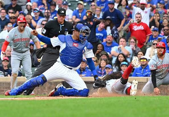 CHICAGO, ILLINOIS - SEPTEMBER 29: Jonathan India #6 of the Cincinnati Reds slides safely into home plate against Christian Bethancourt #60 of the Chicago Cubs during the tenth inning of a game at Wrigley Field on September 29, 2024 in Chicago, Illinois. The Reds defeated the Cubs 3-0. (Photo by Nuccio DiNuzzo/Getty Images)