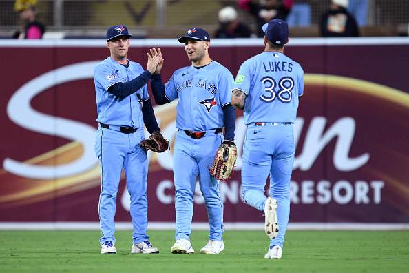 Myles Straw #3, Daulton Varsho #5 and Nathan Lukes #38 of the Toronto Blue Jays celebrate on the field after defeating the San Diego Padres at Petco Park on July 10, 2026 in San Diego, California.