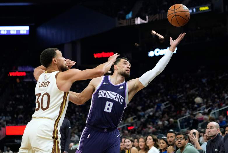 Zach LaVine shoots a layup over Stephen Curry during an NBA game between the Kings and Warriors.