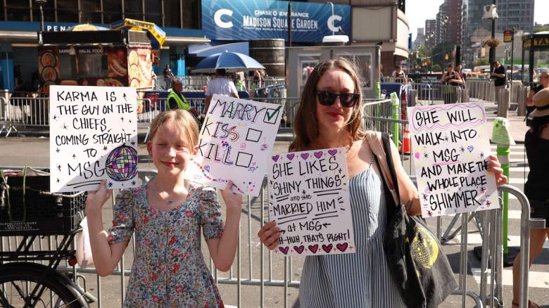Taylor Swift fans hold signs outside Madison Square Garden.