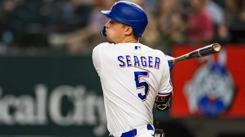 Corey Seager #5 of the Texas Rangers follows through after hitting a single.