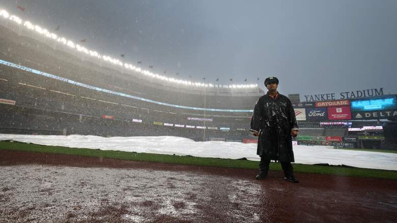 Detective Felipe Ortiz of the New York Police Department stands on the field during a rain delay