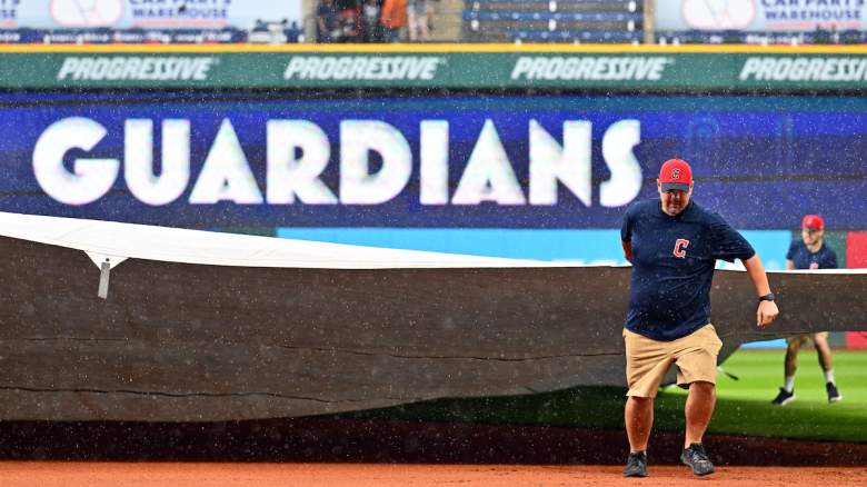 The Cleveland Guardians' grounds crew covers the field for a rain delay