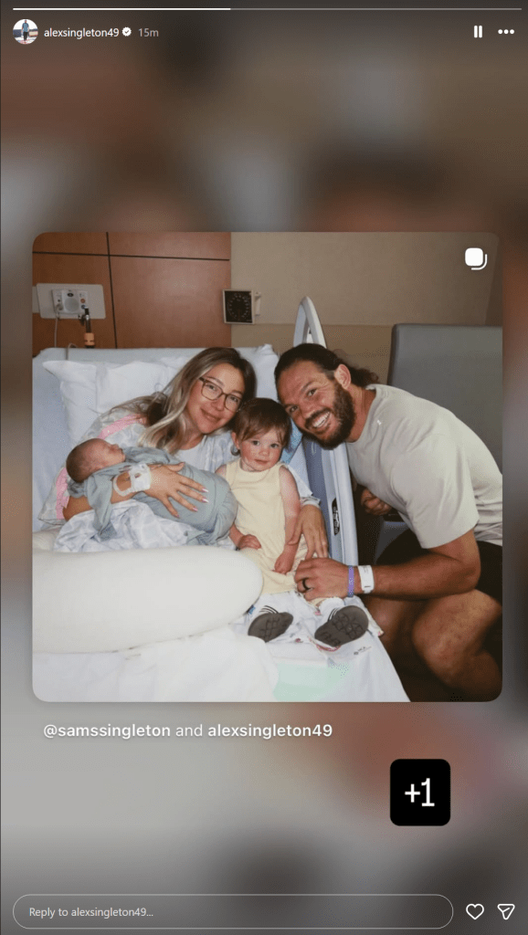 Alex Singleton poses with wife Sam, their daughter and newborn baby in a hospital room.