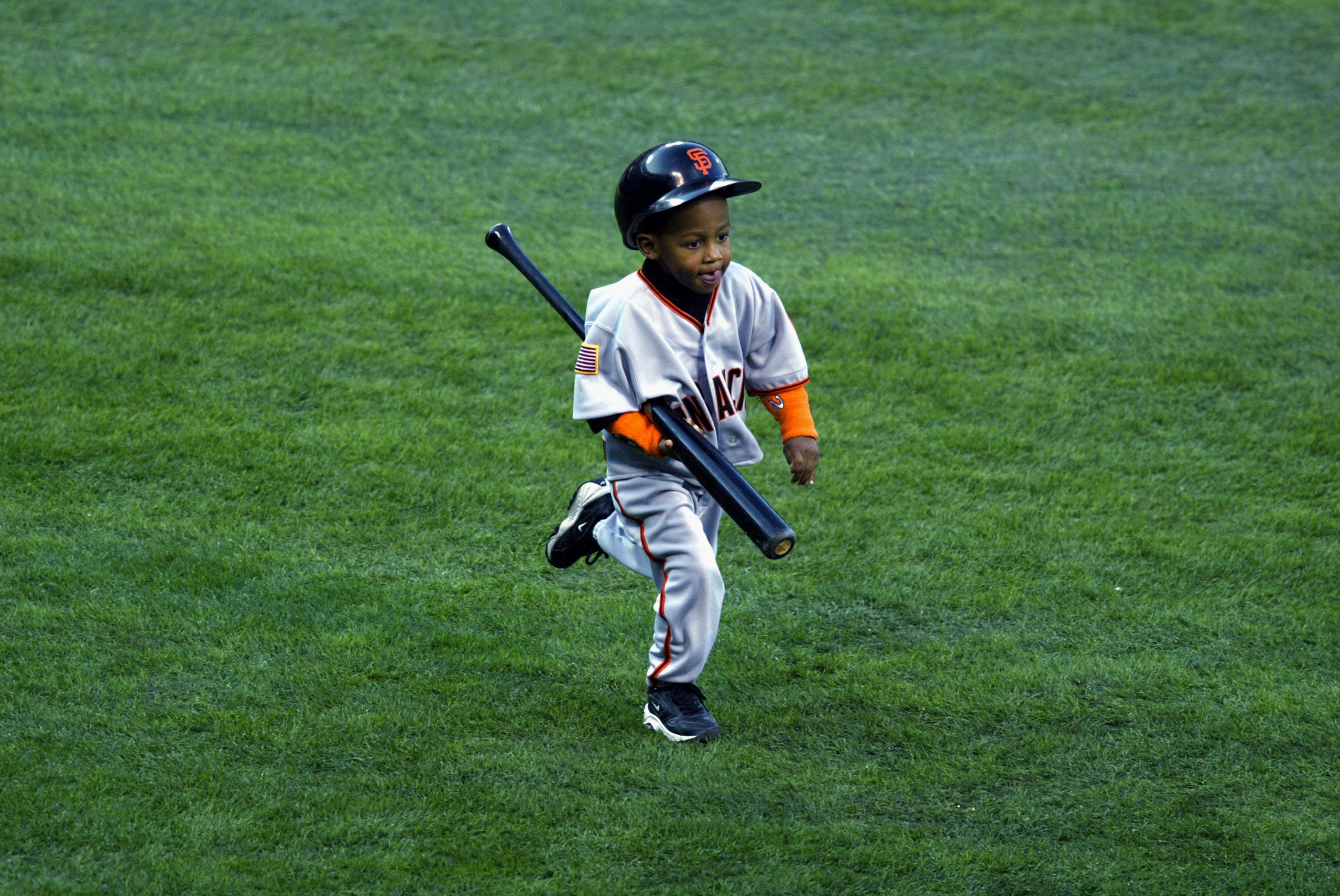 Darren Baker carries a bat back to the dugout