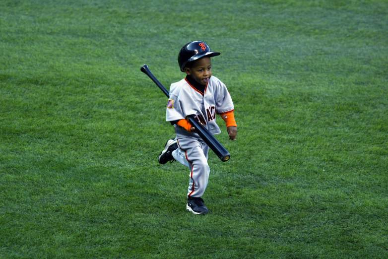 Darren Baker carries a bat back to the dugout