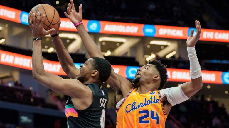 De'Aaron Fox (L) is defended by Brandon Miller.