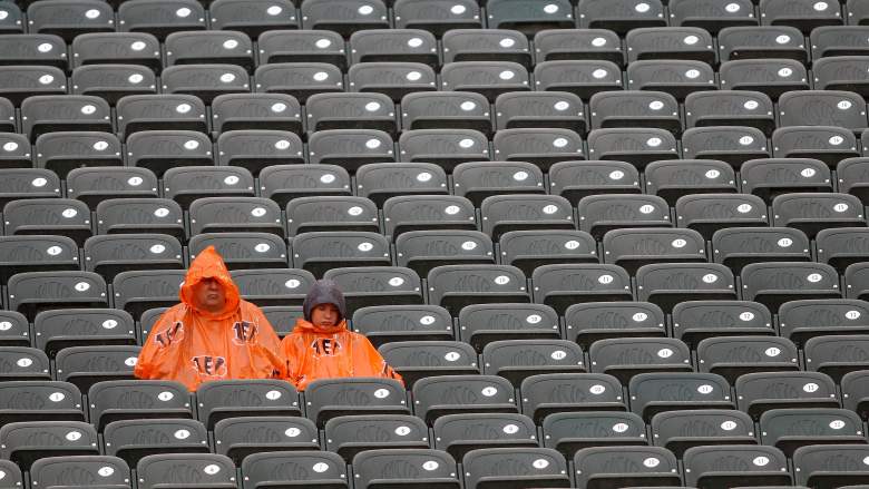 Cincinnati Bengals fans wearing orange rain ponchos sit in the stands during rainy conditions at Paul Brown Stadium in 2017.