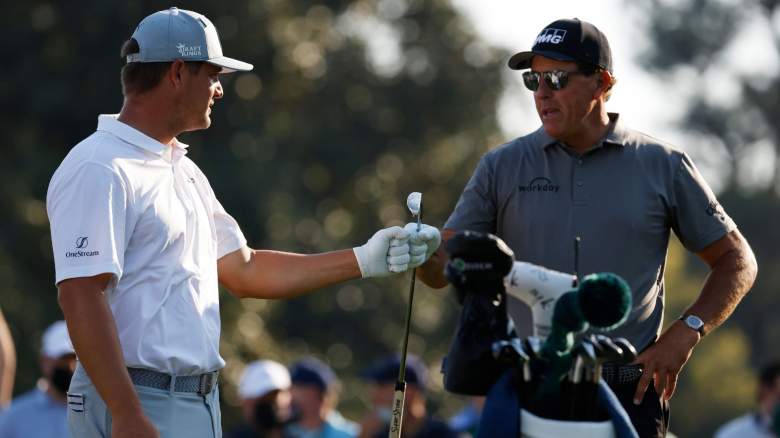 Bryson DeChambeau of the United States and Phil Mickelson of the United States bump fists during a practice round prior to the Masters at Augusta National Golf Club on April 07, 2021 in Augusta, Georgia